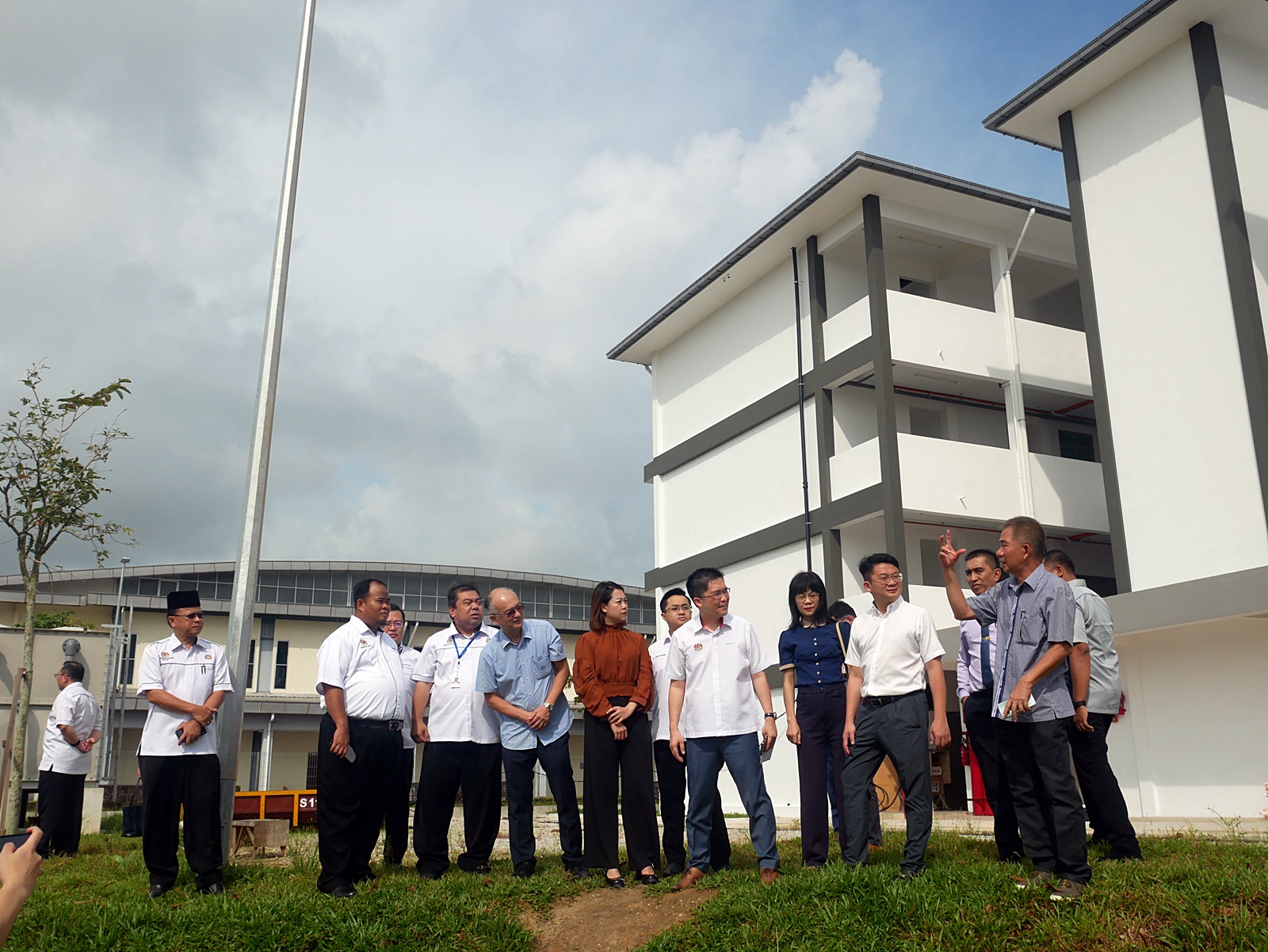 ■黄家和（前左6）到培才华小巡视建设情况。左5是廖彩彤、左7是黄友凤。