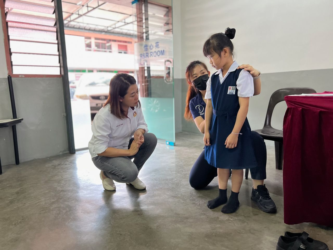 ■廖彩彤(左)巡视学生进行脊椎检查。