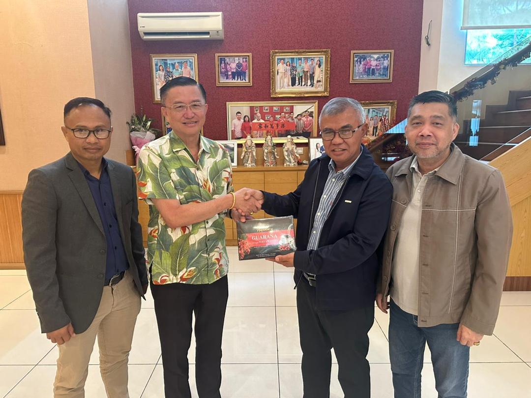 ■苏卡诺（右2）赠送纪念品给郑修强（左2），出席者包括末哈利登（左）及拿督叶偎汕（右）