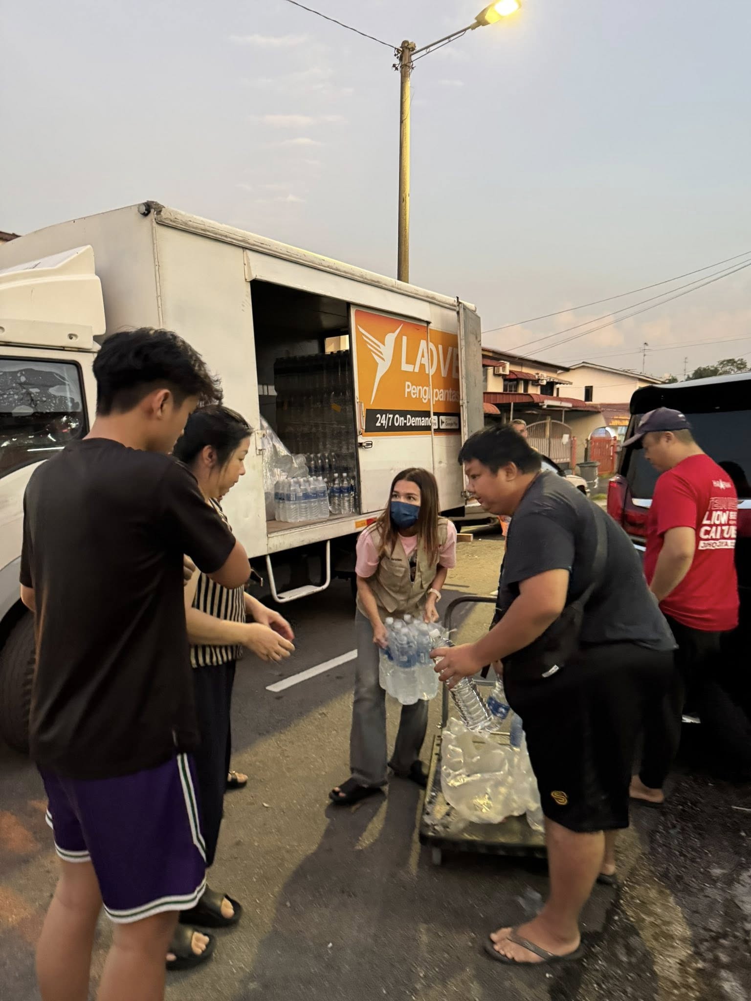 ■玛丽娜（中）派矿泉水给受制水影响的居民。