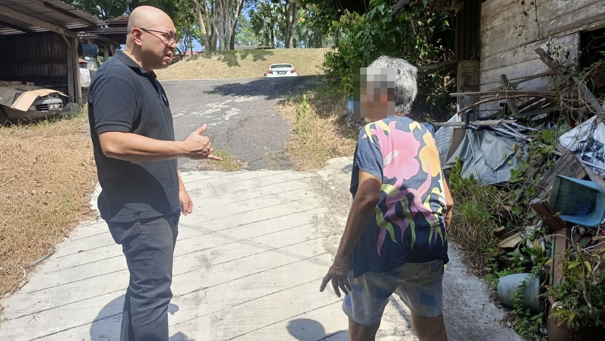 ■村长曾伟力（左）向老妇了解被袭胸经过。