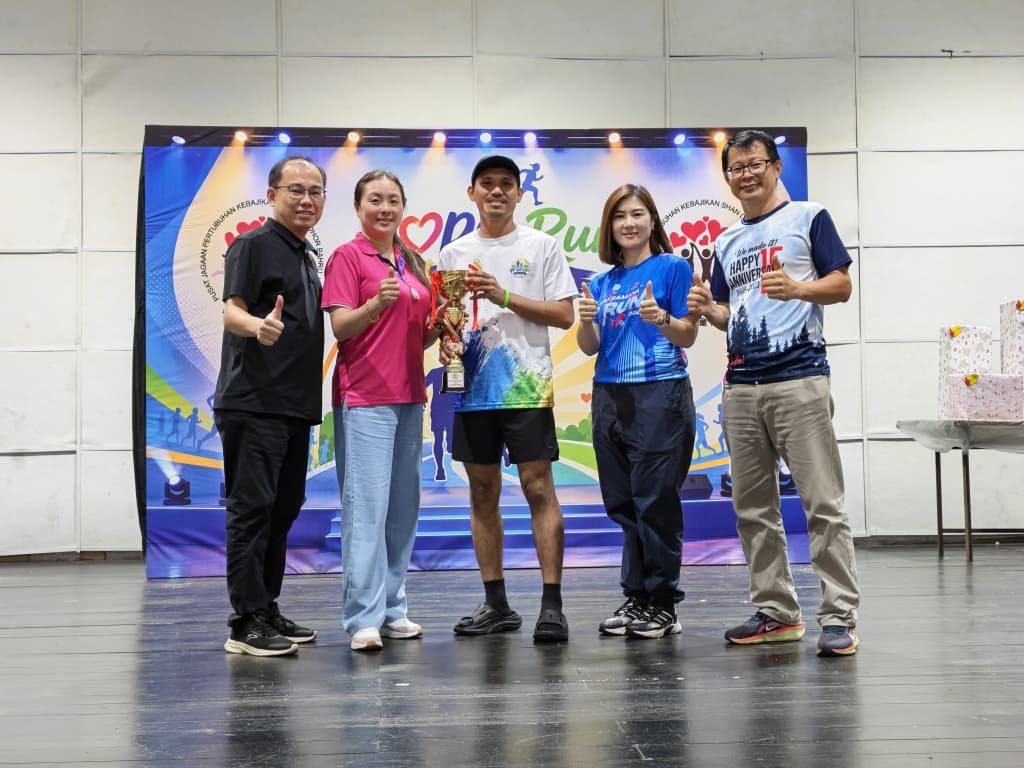 ■邱孝利（左起）与该中心主席谢宝慧颁发奖杯给给义跑冠军得主。依城市议员倪顺海（右起）及陈贤琦陪同。